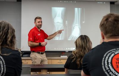 The team physician presents an x-ray to pre-health students.